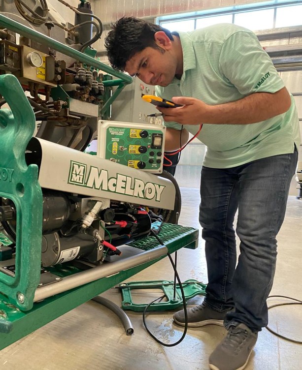PPW technician inspecting McElroy machinery in the workshop